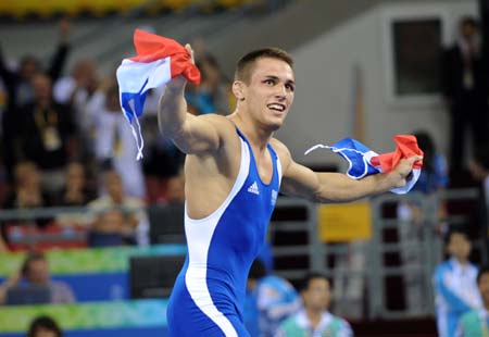 Steeve Guenot of France celebrates during the men's Greco-Roman 66kg final of wrestling against Kanatbek Begaliev of Kyrgyzstan in red at Beijing 2008 Olympic Games in Beijing, China, Aug. 13, 2008. Steeve Guenot of France won the gold medal in the match.