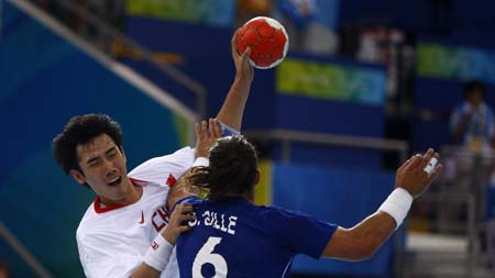 Miao Qing (L) of China attacks during Men's Preliminaries Group A-Match 9 between China and France of Beijing 2008 Olympic Games handball event at OSC Gymnasium in Beijing, China, Aug 12, 2008. France beat China 33-19.[Xinhua] 