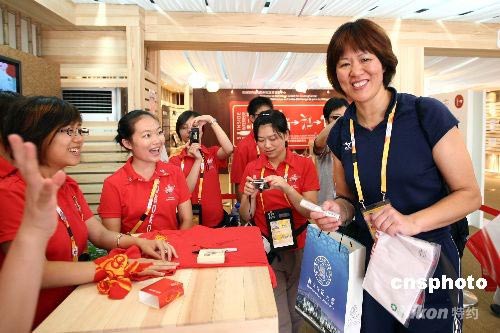 Former Chinese volleyball icon Lang Ping, coach of the US women's volleyball team, get a T-shirt, made of cotton and recycled polyethylene terephthalate extracted from plastic bottles, in the Olympic Village in Beijing on August 5.