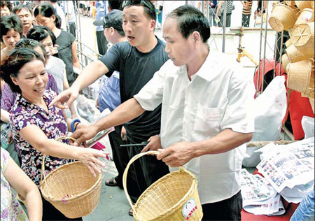 Chen Fei distributes environmentally friendly bamboo baskets in Wenzhou, Zhejiang province, last week, continuing his campaign to limit the use of ultra-thin plastic bags. 