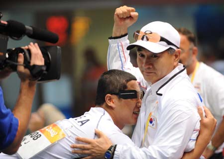 Jin Jong Oh (L) of South Korea celebrates his victory with his coach after winning the gold in men's 50m pistol final of the Beijing 2008 Olympic Games shooting event in Beijing, Aug. 12, 2008. (Xinhua/Jiao Weiping)