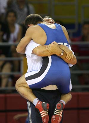 Vitaliy Rahimov of Azerbaijan hugs his coach after defeating Nurbakyt Tengizbayev of Kazakhstan at the men's Greco-Roman 60kg semifinal at the Beijing 2008 Olympic Games wrestling event in Beijing, China, Aug. 12, 2008. Rahimov won the match. (Xinhua/Lu Mingxiang)