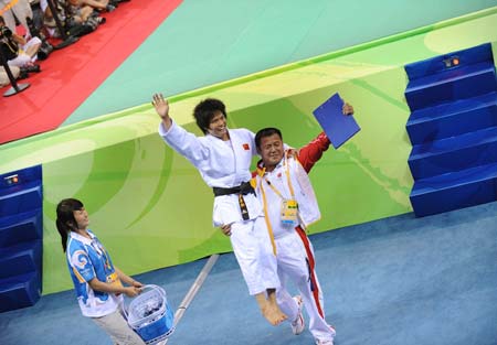 Xian Dongmei of China is lifted by her coach after she defeats An Kum Ae of the Democratic People’s Republic of Korea during the women -52 kg final of judo at the Beijing Olympics in Beijing, China, Aug. 10, 2008. Xian Dongmei gained the gold medal of the event. (Xinhua/Guo Dayue)