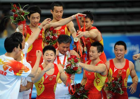 Chinese gymnasts present their gold medals to their head coach Huang Yubin(C) after the awarding ceremony for gymnastics artistic men's team final of the Beijing 2008 Olympic Games at National Indoor Stadium in Beijing, China, Aug. 12, 2008. The Chinese team won the gold medal of the event with 286.125 points (Xinhua/Cheng Min)