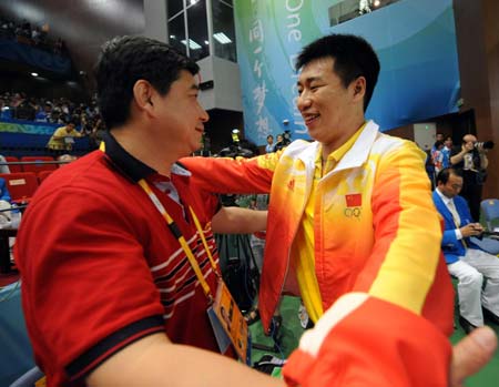 Pang Wei (R) of China celebrates with his coach Wang Yifu after men's 10m air pistol final of Beijing Olympic Games at Beijing Shooting Range Hall in Beijing, China, Aug. 9, 2008. Pang Wei won the gold medal in men's 10m air pistol final. (Xinhua/Jiao Weiping) 