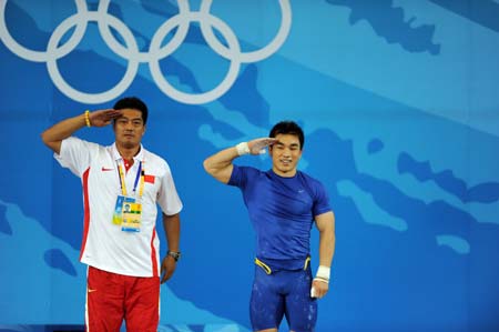 Liao Hui (R) of China and his coach salute to spectators after winning the men's 69kg final of weightlifting at Beijing 2008 Olympic Games in Beijing, China, Aug. 12, 2008. Liao won the gold medal with a total of 348 kilos. (Xinhua/Xu Yu) 