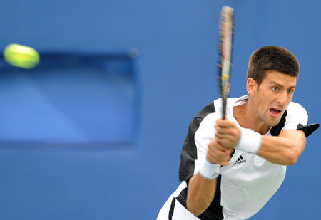 Novak Djokovic of Serbia returns the ball to Mikhail Youzhny of Russia during a match in men's singles third round of the Beijing 2008 Olympic Games tennis event in Beijing, China, Aug. 13, 2008. [Xing Guangli/Xinhua]