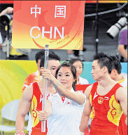 Former gymnast Chen Xi ushers the Chinese gymnastics team into the match venue on Tuesday. [China Daily] 