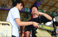 A visitor to Zhongshan Park undergoes a routine security check yesterday. [Wang Jing/China Daily]