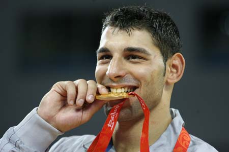Andrea Minguzzi of Italy bites his gold medal during the awarding ceremony of the men's Greco-Roman 84kg final at the Beijing 2008 Olympic Games wrestling event in Beijing, China, Aug. 14, 2008. Andrea Minguzzi beat Zoltan Fodor of Hungary and grabbed the gold medal. 