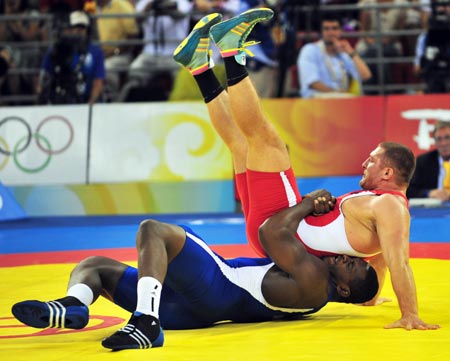 Mijain Lopez (blue) of Cuba wrestles with Khasan Baroev of Russia during the men’s Greco-Roman 120kg final at the Beijing 2008 Olympic Games wrestling event in Beijing, China, Aug. 14, 2008. Mijain Lopez won the bout and grabbed the gold medal. 