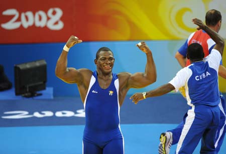 Mijain Lopez of Cuba celebrates after defeating Khasan Baroev of Russia during the men's Greco-Roman 120kg final at the Beijing 2008 Olympic Games wrestling event in Beijing, China, Aug. 14, 2008. Mijain Lopez of Cuba won the bout and grabbed the gold medal. 