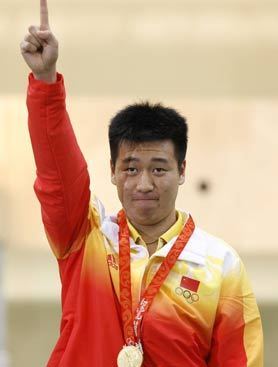 Pang Wei (L) and Wang Wei (R) wave to the audience after both winning a gold medal in shooting event of the Beijing 2008 Olympic Games. [Xinhua]
