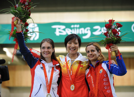 Gold medalist Du Li(C) of China, silver medalist Katerina Emmons of Czech Republic and bronze medalist Eglis Yaima Cruz of Cuba wave to spectators at the awarding ceremony of the women's 50m rifle 3 positions final at Beijing 2008 Olympic Games in Beijing, China, Aug. 14, 2008. Du set a new Olympic record and claimed the title in this event. [Jiao Weiping/Xinhua] 