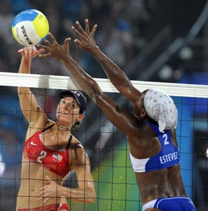 Elaine Youngs (L) of the United States smashes the ball to Cuba's Imara Estevez at the women's preliminary pool E match of the Beijing 2008 Olympic Games beach volleyball event in Beijing, China, Aug. 13, 2008. Nicole Branagh and Elaine Youngs of the United States beat Imara Estevez and Milagros Crespo of Cuba 2-1. (Xinhua/Sadat)