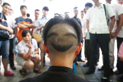 Zheng Yu, 30, who sells his laughs in a Chongqing street, shows his hairstyle on August 3, 2008. 