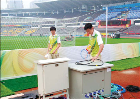 China Netcom staff test lines carefully at the stadium before events begin. [China Daily]