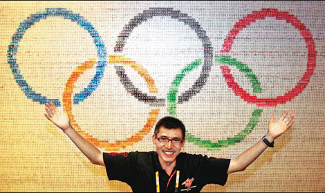 Zhang Jin and the special banner composed of Beijing Olympic torchbearers' images. [Shi Chunyang/China Daily]