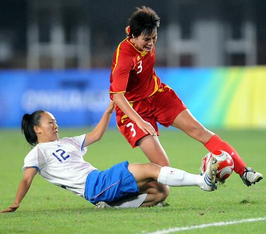 Chinese player Li Jie scrambles for the ball with a Japanese player. 