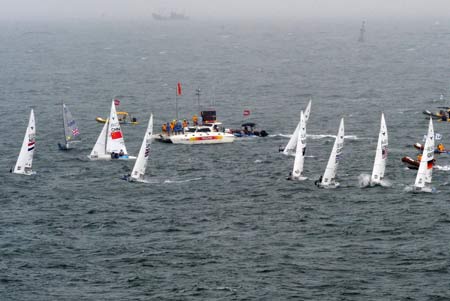 Dinghies compete in the rain during the Yngling medal race at the Beijing 2008 Olympic Games sailing event at Qingdao Olympic Sailing Center in Qingdao, an-Olympic co-host city in eastern China’s Shandong Province, Aug. 17, 2008. The British team won the gold medal of the event. [Song Zhenping/Xinhua] 