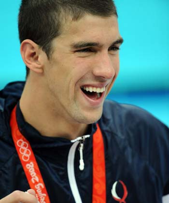 Michael Phelps of the United States smiles during the awarding ceremony of the Men's 4X100M Medlay Relay final at the Beijing 2008 Olympic Games in the National Aquatics Center, also known as the Water Cube in Beijing, China, Aug. 17, 2008. Phelps won his eighth gold medal at the Beijing Olympics swimming events on Sunday, breaking Mark Spitz's record of seven gold medals won at a single Games in 1972. (Xinhua/Chen Kai)