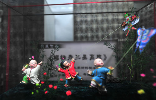 This photo taken on August 17, 2008 shows 'three children flying kites,' a dough figurine artwork on display at Baigongfang, a museum of traditional Chinese handicrafts in Beijing. [Photo: Xinhua]