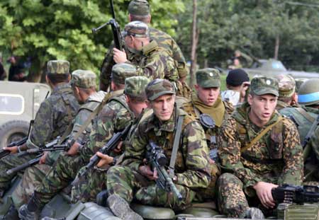 Russian troops ride atop armored vehicles near the village of Khurcha heading towards the border of Georgia in breakaway region of Abkhazia August 10, 2008.  (Xinhua/Reuters Photo)