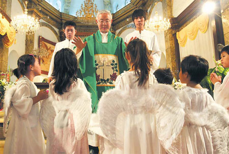 Father Peter Zhao Jianmin (center) conducts mass at the Catholic Church of Xuanwumen in Beijing, August 17, 2008. [China Daily] 