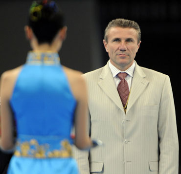 International Olympic Committee Co-ordination commission chairman Sergey Bubka (R) looks on during the medal ceremony of the women's floor final of the artistic gymnastics event of the Beijing 2008 Olympic Games in Beijing on August 17, 2008. [Agencies]