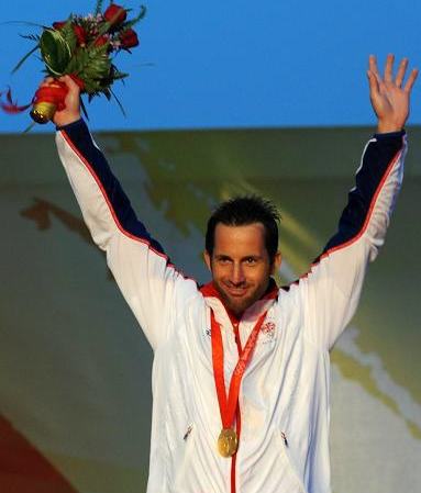 Ben Ainslie of Britain waves to specutators after winning the the Finn gold medal at Olympic sailing regatta here on August 17, 2008.[Xinhua] 