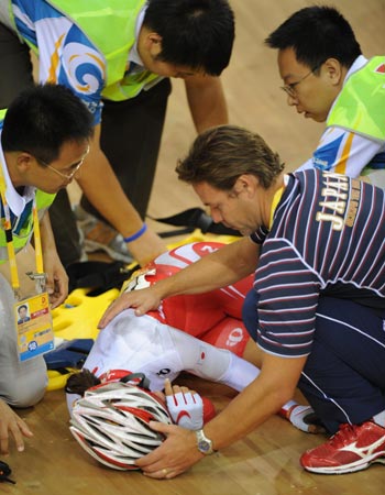 Tracks cyclist Satomi Wadami of Japan is assisted after a crash during the women's points race of the Beijing Olymic Games cycling-track event at Laoshan Velodrome in Beijing, China, Aug. 18, 2008. [Xinhua] 