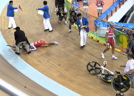 Tracks cyclist Satomi Wadami of Japan is assisted after a crash during the women's points race of the Beijing Olymic Games cycling-track event at Laoshan Velodrome in Beijing, China, Aug. 18, 2008. [Xinhua] 