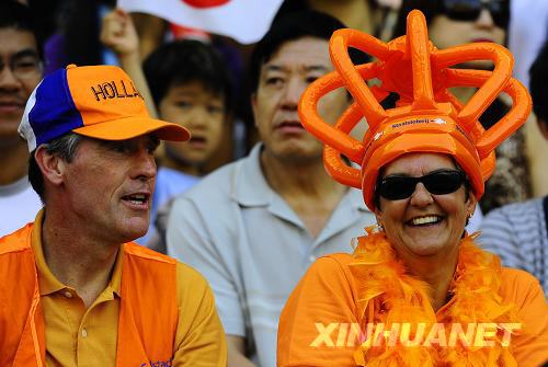 Wearing a 'Bird's Nest' hat, a Holland fan watches a football match at Shenyang Olympic Sports Center on August 13. Holland beat Japan 1-0 in Men's soccer group B. [Ren Yong/Xinhua]