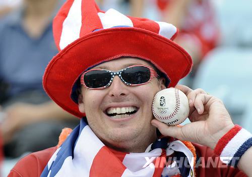 American fan Eric Cobb wears a red, white and blue hat and stars and stripes glasses at a baseball preliminary contest in the Wukesong Sports Center on August 14. [Guo Lei/Xinhua] 