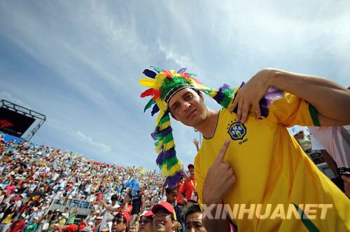 A Brazilian fan shows off his colorful, native-American headdress and Brazil football shirt while watching Beach volleyball in Chaoyang Park on August 16. [Sha Dati/Xinhua] 