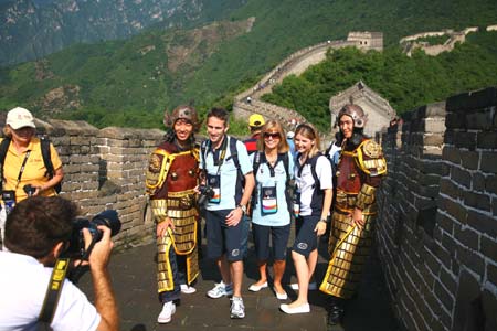 Foreign tourists pose for pictures with two tourists wearing ancient Chinese armatures the Mutianyu section of the Great Wall in Beijing, capital of China, August 18, 2008. The Great Wall attracts many foreign visitors and athletes during the Beijing 2008 Olympic Games. [Xinhua]