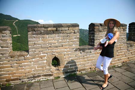 A foreign tourist, carrying her child in arms, visits the Mutianyu section of the Great Wall in Beijing, capital of China, August 18, 2008. The Great Wall attracts many foreign visitors and athletes during the Beijing 2008 Olympic Games. [Xinhua] 