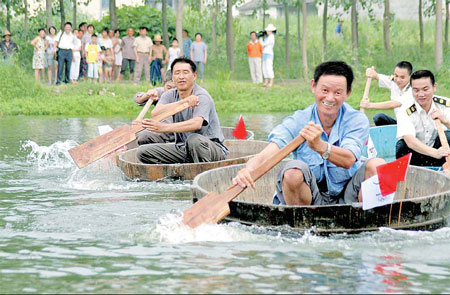 Men in Daqing, Zhejiang province, take part in their own version of Olympic rowing yesterday. Xinhua