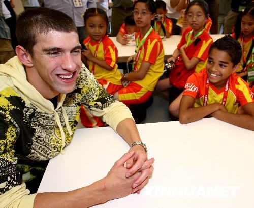 American swimming prodigy Michael Phelps, who won eight gold medals at the Beijing Olympics, talks with representatives of Olympic 'champion' children selected from around the world by McDonald's, an Olympic sponsor, on Monday, August 18, 2008. Phelps shared his happiness over his gold medal run with these little representatives of the Golden Arches. [Photo: Xinhua]
