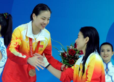 Gold medalist Guo Jingjing (2nd R) of China shakes hands with her teammate bronze medalist Wu Minxia (3rd R) during the awarding ceremony of women's 3m springboard at the Beijing 2008 Olympic Games in the National Aquatics Center, also known as the Water Cube in Beijing, China, Aug. 17, 2008. (Xinhua/Zhao Peng)(