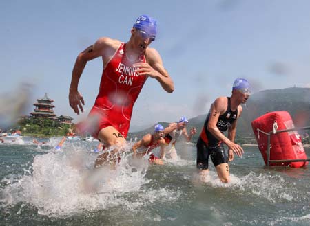  Athletes go ashore after the swim contest of Men's Final of Beijing 2008 Olympic Games triathlon event in Beijing, China, Aug. 19, 2008. (Xinhua/Xing Guangli)