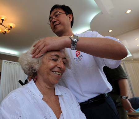 A foreign journalist experiences traditional Chinese medical massage provided by a Chinese medicine doctor at Yu Sheng Tang - Beijing Chinese Medicine Museum, in Beijing, capital of China, Aug. 19, 2008. 