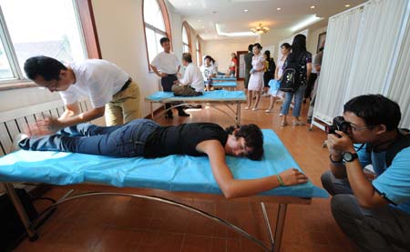 A foreign journalist experiences traditional Chinese medical massage provided by a Chinese medicine doctor at Yu Sheng Tang - Beijing Chinese Medicine Museum, in Beijing, capital of China, Aug. 19, 2008.
