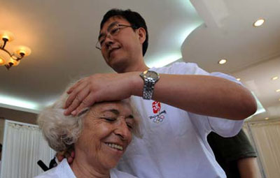 A foreign journalist experiences traditional Chinese medical massage provided by a Chinese medicine doctor at Yu Sheng Tang - Beijing Chinese Medicine Museum, in Beijing, capital of China, Aug. 19, 2008.