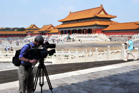 A TV reporter of the United States mans his camera at the Forbidden City in Beijing, capital of China, Aug. 19, 2008. The Forbidden City is among the favorites of foreign tourists during the Beijing Olympic Games.[He Junchang/Xinhua]