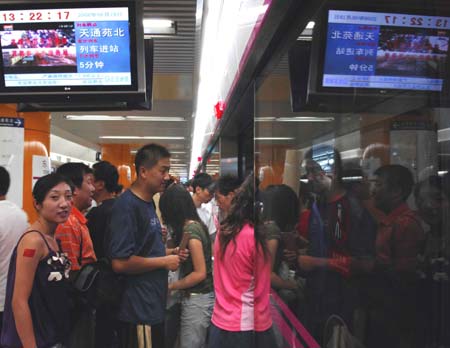 People get onto a train at Dongdan Subway Station in Beijing, capital of China, Aug. 19, 2008. Statistics shows that the public traffic sector has registered a passenger transport volume of 20 million persons per day since the control of vehicle use in Beijing last month.[Zhang Shanchen/Xinhua]