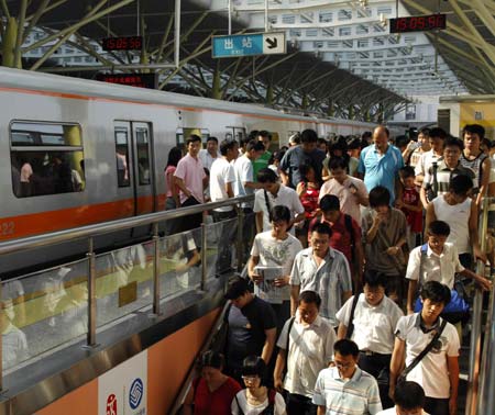 People get off a train at Dongdan Subway Station in Beijing, capital of China, Aug. 19, 2008. Statistics shows that the public traffic sector has registered a passenger transport volume of 20 million persons per day since the control of vehicle use in Beijing last month.[Zhang Shanchen/Xinhua]