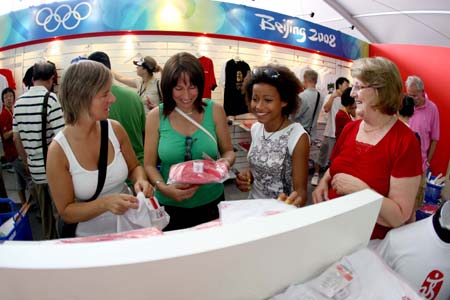 Tourists select the Olympic-related souvenirs at an exclusive shop selling the licensed products of the Beijing 2008 Olympic Games in the Olympic Green in Beijing, capital of China, Aug. 19, 2008. The Olympic-related souvenirs in the shop are sold well as the event is drawing to an end.[Wang Wen/Xinhua]