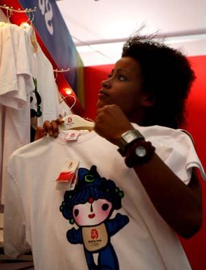 A tourist selects T-shirts printed with 'Fuwa', mascot of the Beijing 2008 Olympic Games, at an exclusive shop selling the licensed products of the Beijing 2008 Olympic Games in the Olympic Green in Beijing, capital of China, Aug. 19, 2008. The Olympic-related souvenirs in the shop are sold well as the event is drawing to an end.[Wang Wen/Xinhua]