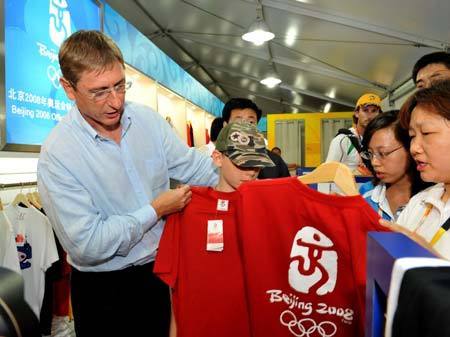 Hungarian Prime Minister Ferenc Gyurcsany (L) selects 'Beijing 2008' T-shirts for his son at the business and culture street in the Olympic Village in Beijing, China, Aug. 16, 2008. Ferenc Gyurcsany bought some Beijing Olympics souvenirs during his visit at the Village Saturday.[Zhang Guojun/Xinhua]